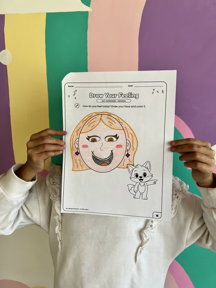 A child holding up a colored Draw Your Feeling page